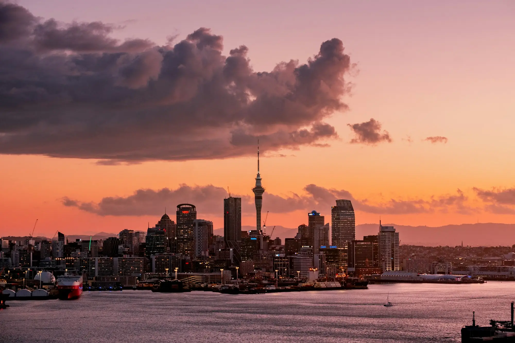 Auckland CBD commercial buildings and Sky Tower at dusk across the Waitematā Harbour