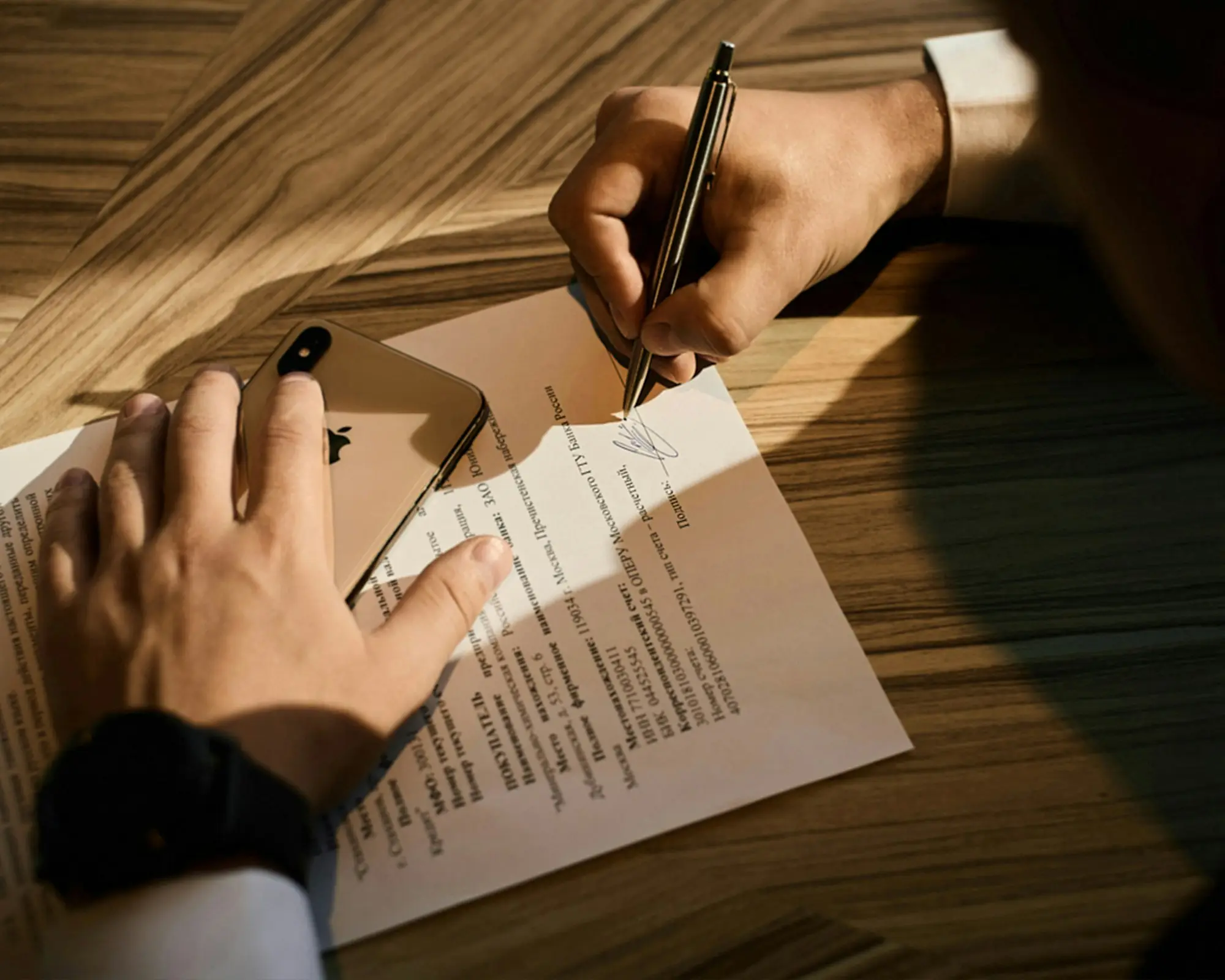 Business owner signing loan documents with a lawyer at a meeting table in Auckland